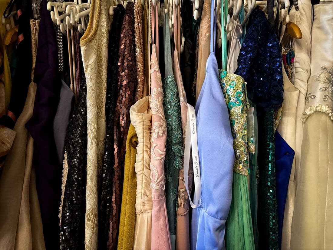 Rail of colourful vintage party dresses with sequins and prints