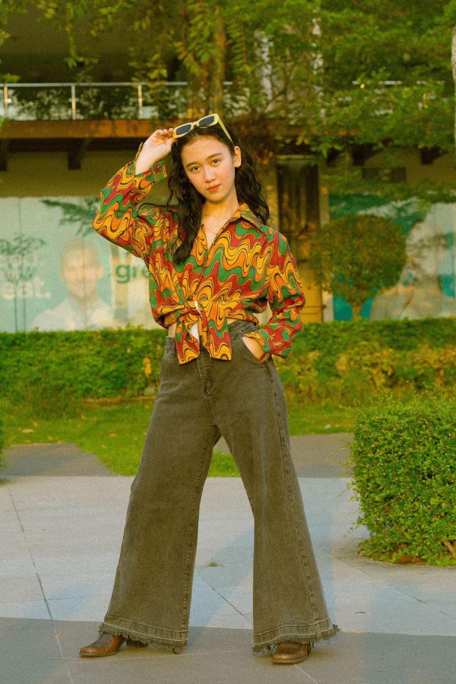 Woman in a bright 70s print shirt and flares