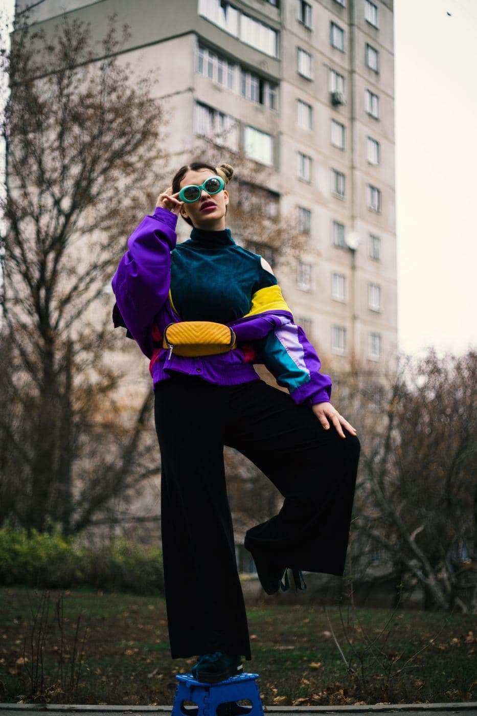 Woman in a purple, teal and mustard 90s colour-block jacket