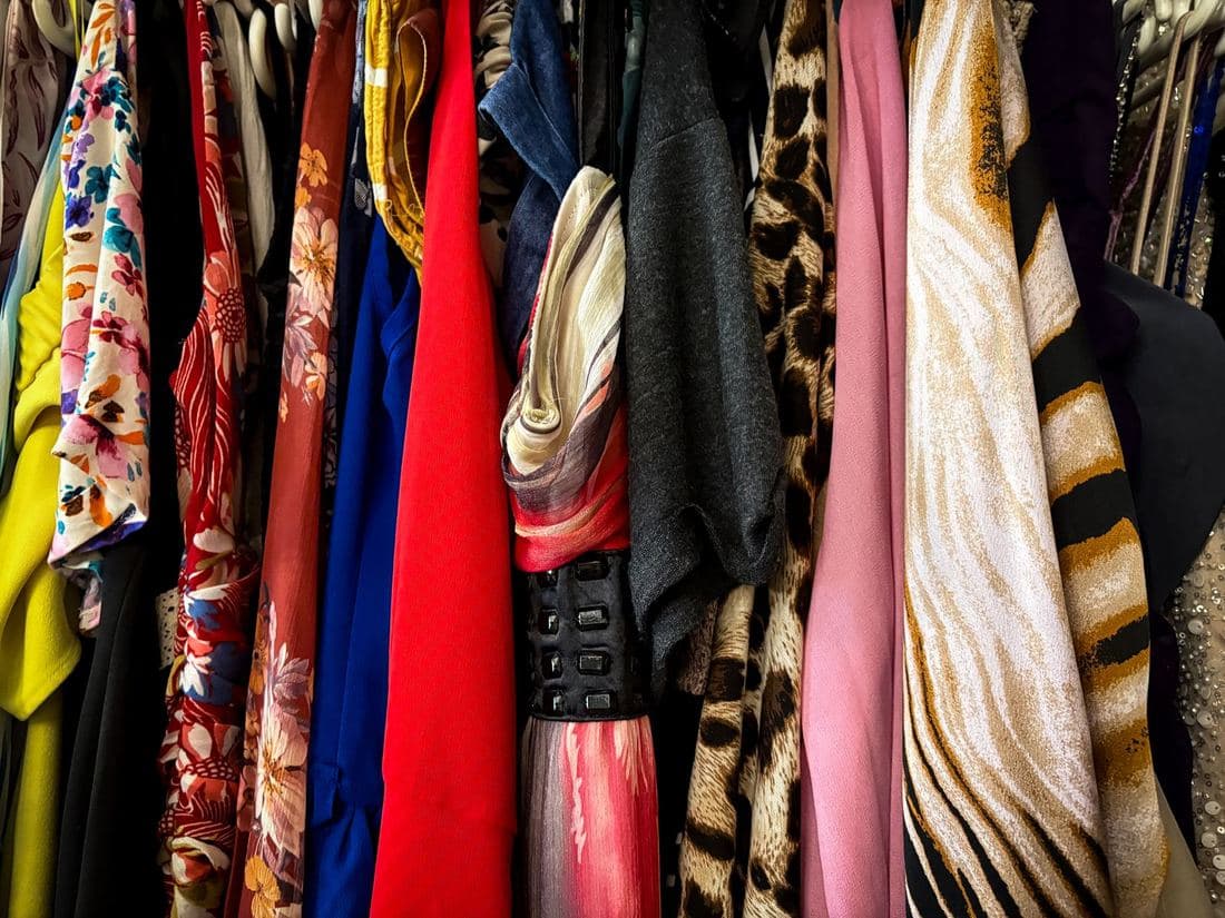 A rail packed with bright vintage shirts and jackets ready for a drop