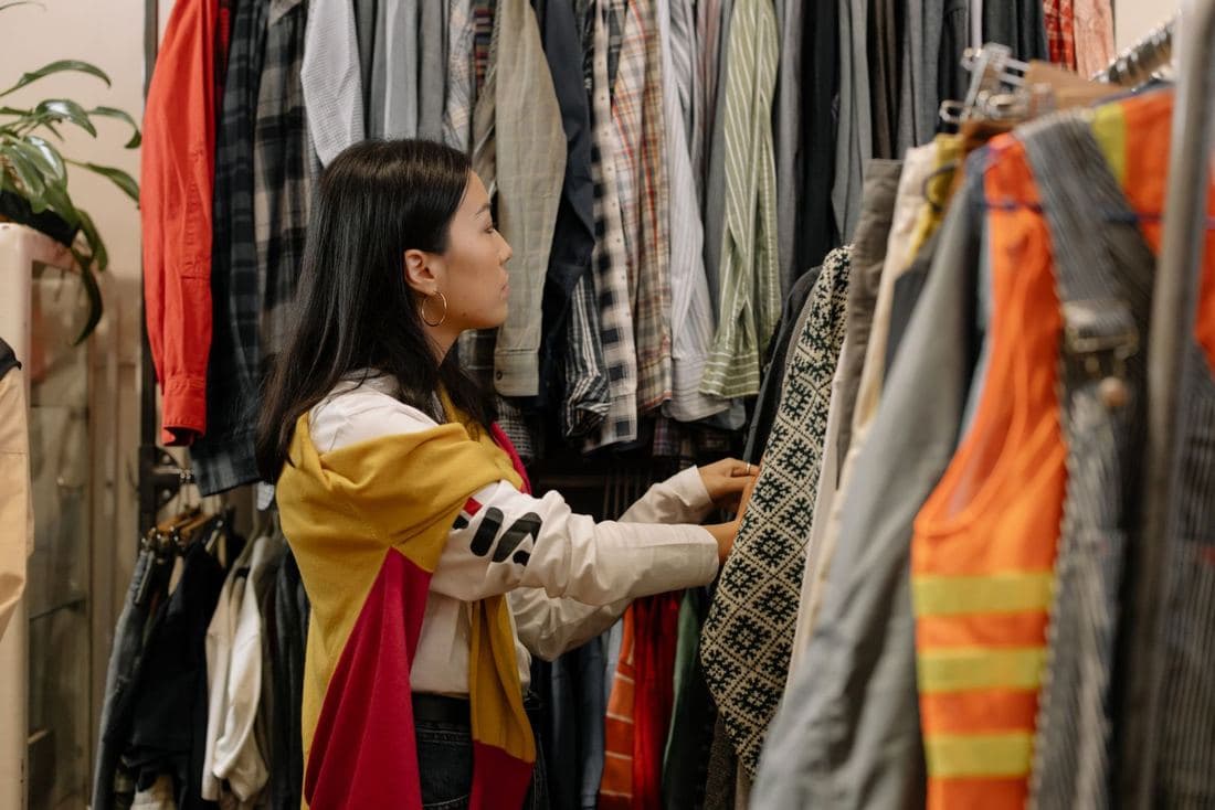 A shopper trying a scarf in a vintage shop